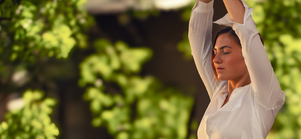 Woman performing yoga for wellness and stress relief at Ayugiri Ayurveda retreat