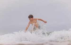 Child playing in gentle surf at Pasikuda Beach, known for safe swimming in Sri Lanka