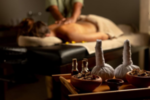 A guest receiving an Ayurvedic massage at Ayugiri, with herbal oils and remedies in the foreground