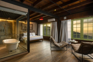 A guest room at Newburgh Ella with exposed steel structure and a view over the tea hills