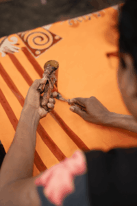Artisan applying wax with a canting tool during batik making
